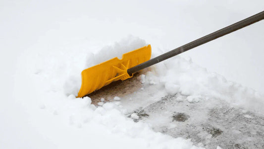 SnowEx pusher shovel clearing heavy snow from a driveway, ideal for Kentucky sidewalks and commercial lots.