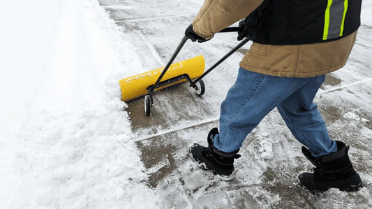 SnowEx pusher shovel clearing snow from a driveway, designed for tough winter conditions in Kentucky.