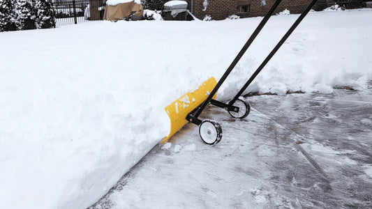 SnowEx pusher shovel with wheels pushing snow, compared to traditional snow shovels for winter efficiency.