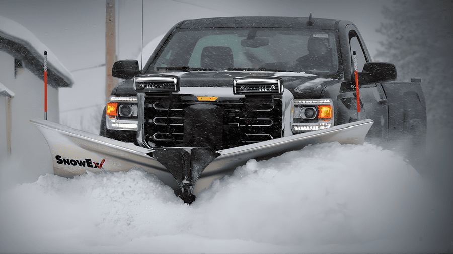 SnowEx snow plow mounted on a pickup truck clearing deep snow, highlighting the benefits of buying SnowEx equipment from a local Somerset, KY dealer.